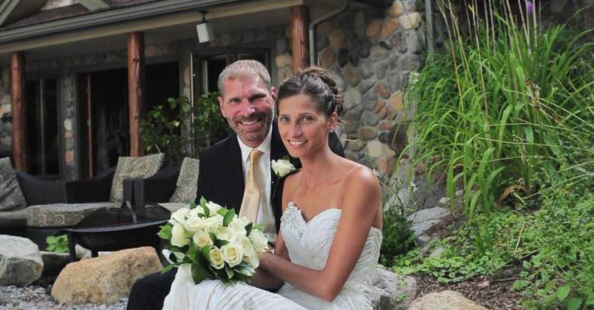 bride and groom smiling happily in front of a lodge