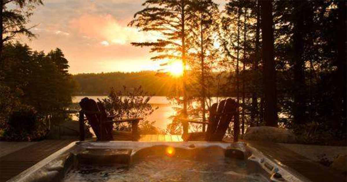 A pair of Adirondack chairs at Fern Lodge look out over a sunset on Friends Lake.