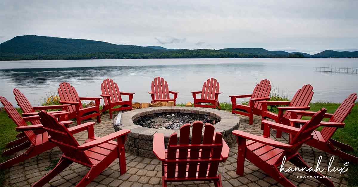 A circle of Adirondack chairs beside Lake Pleasant.