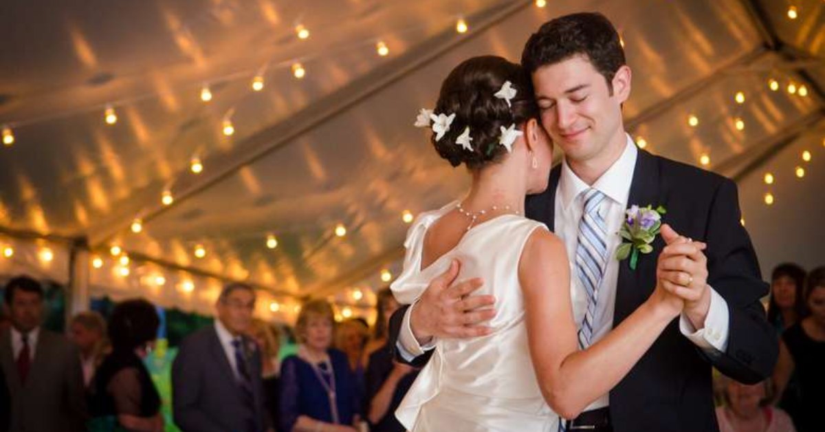 a bride and groom dancing together and smiling