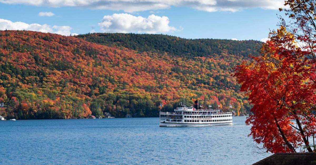 fall foliage surrounding lake with large boat